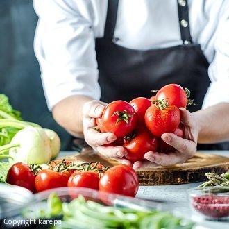 Symbolbild für Catering-Broschüre: Koch mit Tomaten in den Händen